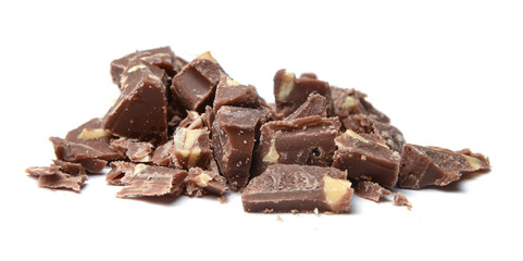 Slices of coarsely grated chocolate with nuts. White isolated background. Close-up. Side view.