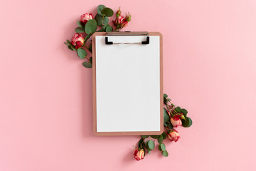 Border frame made of eucalyptus branches and pink roses. Clipboard mockup
