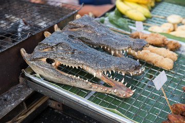 Roasted bbq crocodile head on a street market in Thailand
