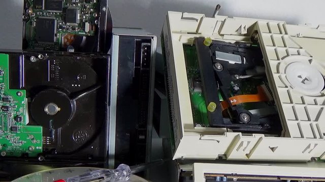 Stack of old SATA, ATA hard disk drives and driver cd disassembled.