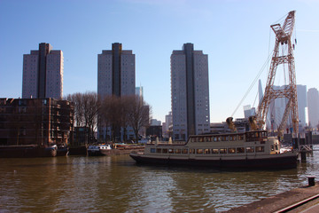 Fototapeta premium The modern and touristic port of Rotterdam on a sunny spring day. In the metropolis boats, ships and fishing boats wake up in the morning ready for work.