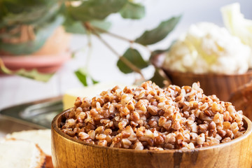 Buckwheat porridge in wooden bowl with space for text. Closeup.