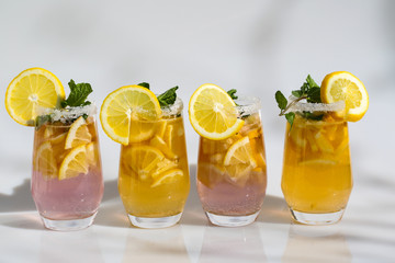 Lemonade with lemon wedges, white background