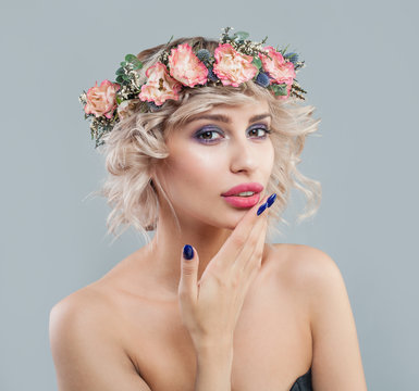 Pretty woman with clear skin, makeup, flowers and short curly haircut portrait