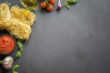 Pasta ingredients for cooking Italian dishes- tagliatelle, tomatoes, basil, olive oil and garlic. Food pattern. Top view with space for text. - obrazy, fototapety, plakaty