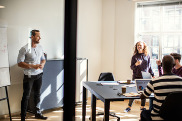 Smiling manager doing a whiteboard presentation inside of an off