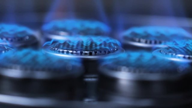 Slow motion Close up shot start ignition to burning fire on gas stove in the dark with dark and grain processed