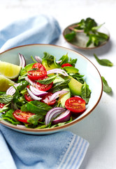 Mixed salad made with cherry tomatoes, arugula, red onion, avocado and mint leaves. Healthy home made food. Close-up