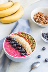 Acai bowl of smoothies with blueberries, banana slices, walnuts, pumpkin seeds and sesame