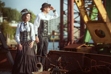 Man and a woman in the style of steampunk, they have costumes of leather corsets.