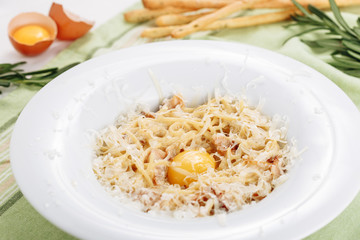 Carbonara Pasta with Ham Egg Yolk and Cheese Side View. Italian Noodles Tagliatelle with Bacon and Parmesan Serving for Gastro Dinner. Homemade Traditional Carbanara Plate for Recipe Photo