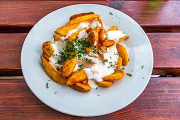 Fried potatoes with white milk sauce and dill