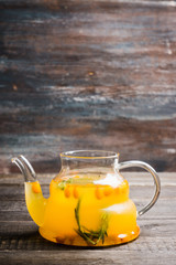 Hot buckthorn beverage in glass teapot. Selective focus. Shallow depth of field. 