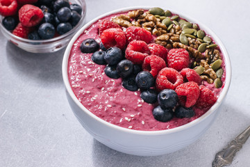 Acai bowl of smoothies with raspberries, blueberries, walnuts, pumpkin seeds and sesame