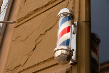 American barber pole sign with a helical stripe (red, white, and blue ) on a wall