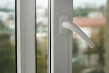 Close up on opened white plastic window handle