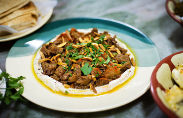 Hummus and meat with arabic snacks on a table