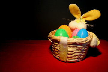 Easter basket with plastic eggs on a wood table. Basket is to the right of the image to allow for text to be placed on the left.