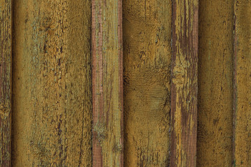 Old yellow peeling paint of wood surface. Old wooden fence. Сracked yellow paint on wooden boards. Vintage wood texture background 