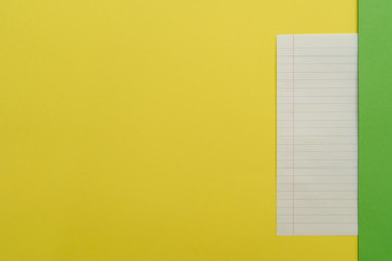 A sheet in a ruler under the thin green paper stripe on the right on a yellow background. Place for text.