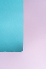 Vertical purple-blue paper background. A piece of blue paper in the up-left corner with torn edges on the background of a sheet of purple paper