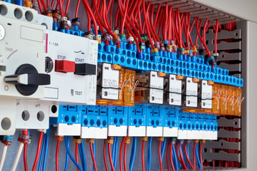 Motor protection circuit breakers and intermediate relays in electrical Cabinet. The wires are connected to the electrical equipment according to the scheme. Automatic control and distribution.