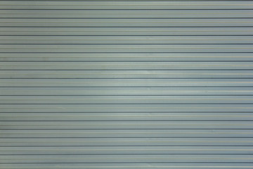 gray white blue metal wall shield with horizontal lines and shadows. rough surface texture