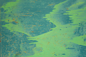 Fototapeta na wymiar old blue metal wall shield with stains of green paint, scratches and dots of brown rust. rough surface texture