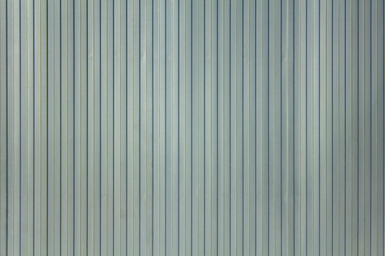 Gray white blue metal wall shield with vertical lines and shadows. rough surface texture