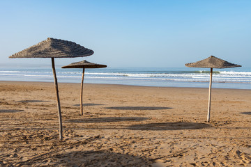 Three Wood Umbrellas on a Beach in Essaouira Morocco