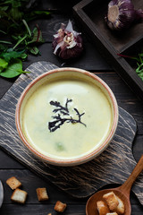 Creamy soup puree with spinach on a dark background