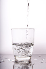 water pouring into a glass isolated on white background