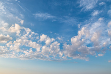 Small low-altitude clouds and dark blue sky on the background