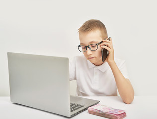boy with money and laptop at the table on white background