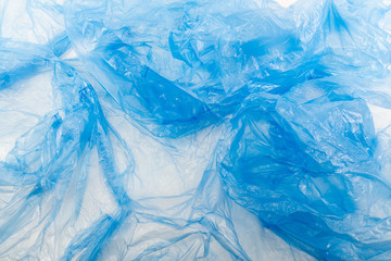 Wrinkled crumpled blue plastic wrap thrown on the floor