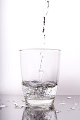 water pouring into glass isolated on white background