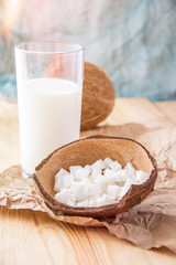 Coconut slices and a glass of milk.Coconut on a wooden table.Vegan non dairy healthy drink