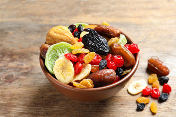 Bowl with different dried fruits on wooden background. Healthy lifestyle