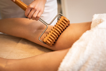 Close up of anticellulite massage with maderotherapy wooden rolling pin