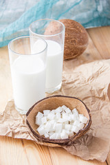 Coconut slices and a glass of milk.Coconut on a wooden table.Vegan non dairy healthy drink