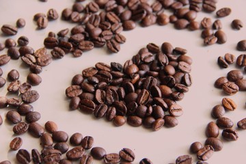 lots scattered on the table roasted coffee beans in the shape of a heart, close up