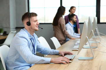 Technical support operator working with colleagues in office