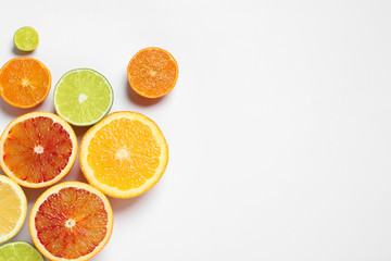 Composition with different citrus fruits on white background, top view