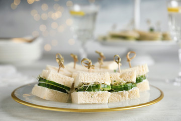 Plate with traditional English cucumber sandwiches on table. Space for text