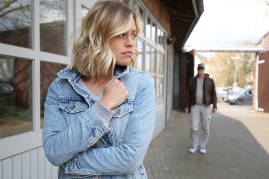 Junge Frau f&uuml;hlt sich von einem Mann verfolgt