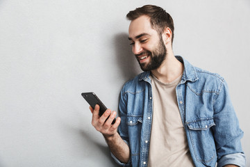 Excited cheerful man wearing shirt standing isolated