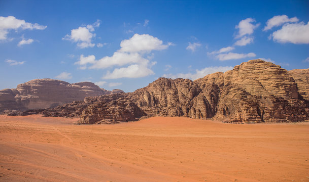 Wadi Rum Jordan Middle East panorama scenery desert landscape sand valley foreground and bare rocky mountain ridge background with vivid blue sky, travel planet and discovery  concept photography