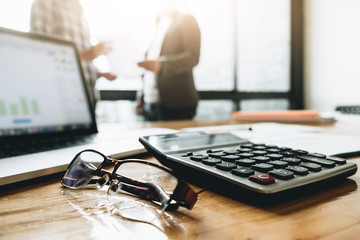 Close up Businessman and partner using calculator and laptop for calaulating finance, tax, accounting, statistics and analytic research concept