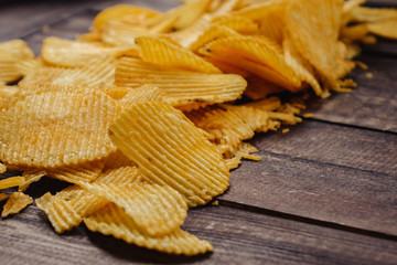 crispy potato chips on wooden background. chips started
