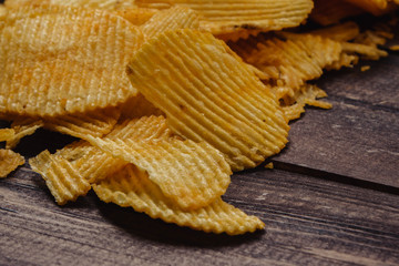 crispy potato chips on wooden background. chips started